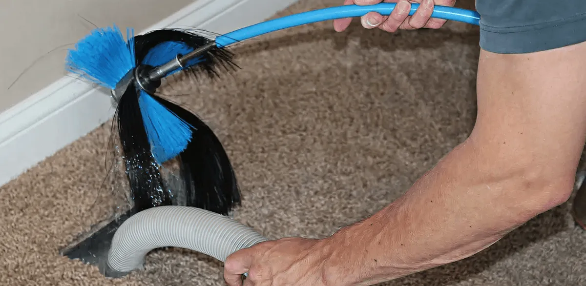 Dryer vent cleaning technician brushing lint from a vent line in Nashville, TN