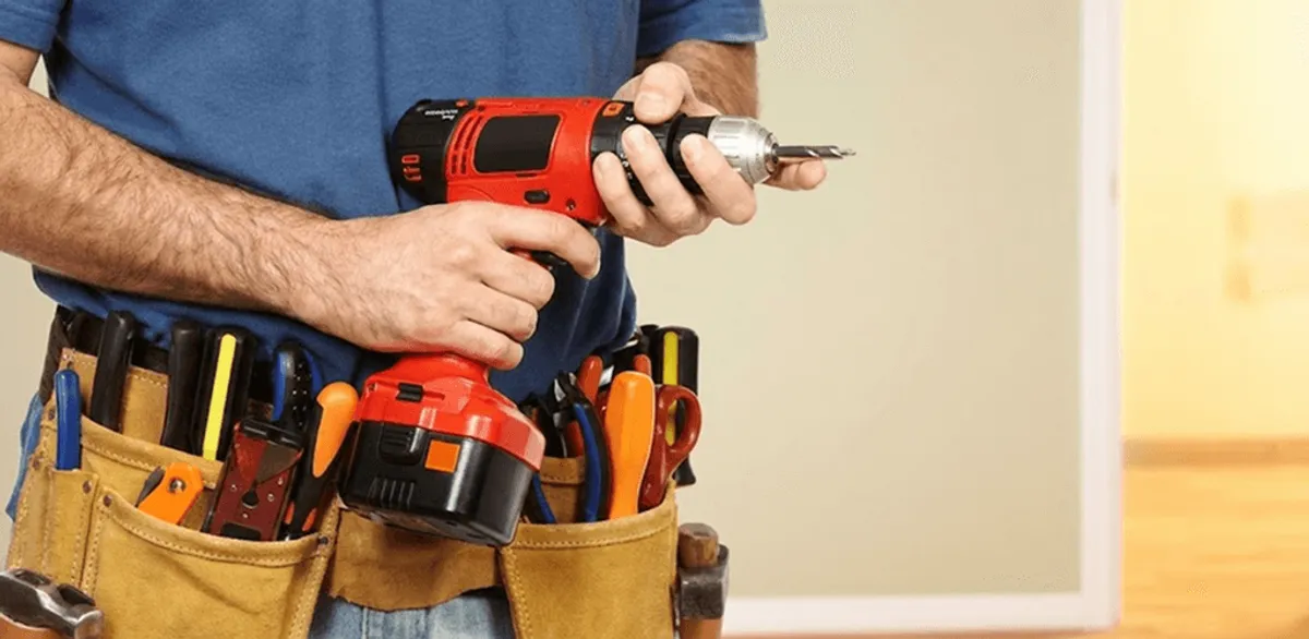 Handyman holding a power drill for home repairs and installations in Nashville, TN
